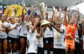 Jogadoras do Corinthians comemorando o ttulo da Supercopa do Brasil junto  taa da competio