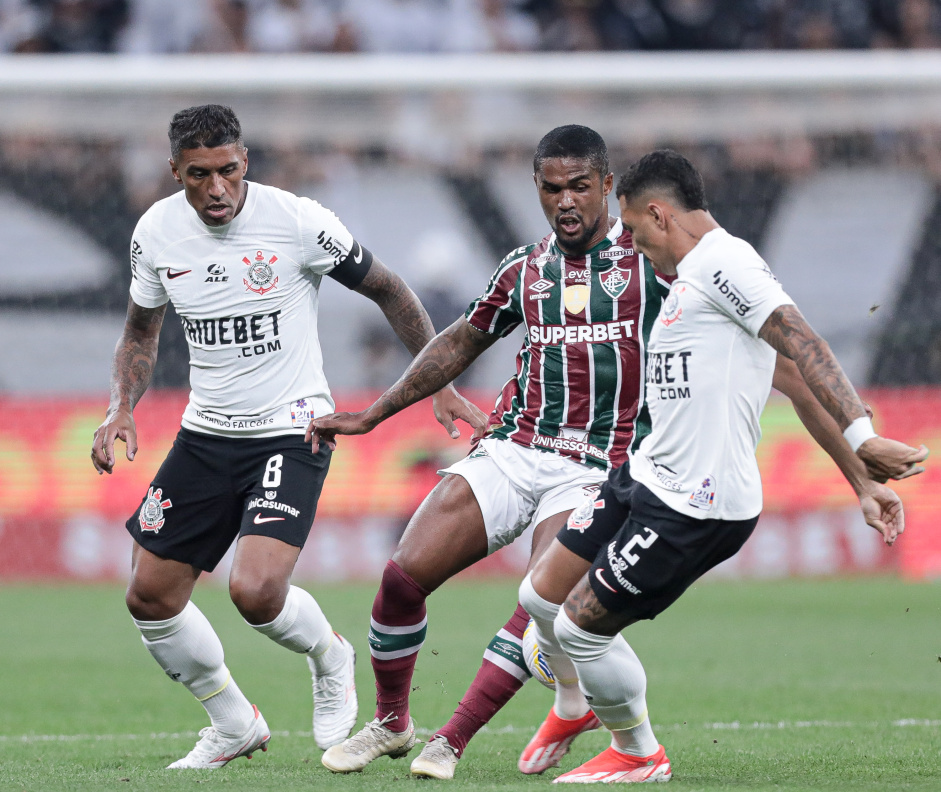 Matheuzinho e Paulinho tentando roubar a bola de atacante do Fluminense