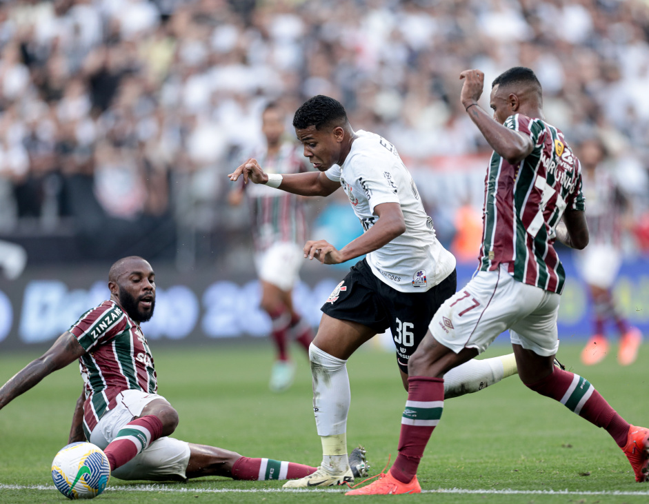 Wesley passando por entre dois jogadores do Fluminense, que tentam desarm-lo