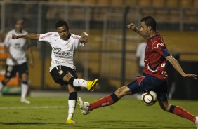 Dentinho chuta a bola em cima de Alselmo de Almeida durante partida entre Corinthians X Independiente de Medellin válida pela Copa Santander Libertadores realizada no estádio do Pacaembu
