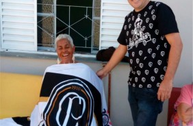 Senhora apelidada de 'Totoso' exibe orgulhosa a bandeira que recebeu em uma das visitas anteriores