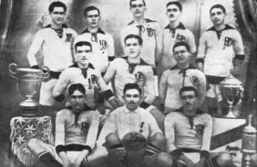 Elenco campeão paulista em 1914 ao lado da taça do primeiro título do Corinthians