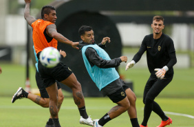 Matheus Bidu e Paulinho disputando bola no treino do Corinthians; Donelli aparece ao fundo