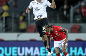 Murillo cabeceando a bola após vencer disputa com jogador do Internacional