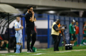 Arthur Elias com a mo na boca na beira do gramado da Fazendinha