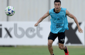 Roni, de colete, observando a bola durante treino