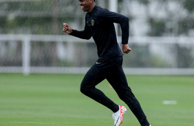 Felipe Augusto correndo sorridente no gramado do CT