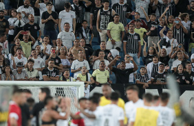 Torcida do Corinthians na Arena das Dunas no jogo contra o Amrica-RN; jogadores aparecem desfocados