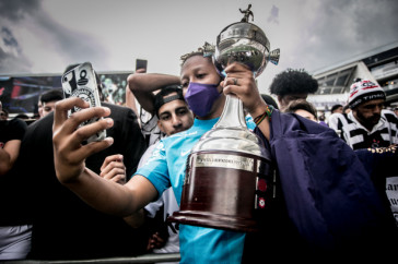 Goleira Paty com torcedores e taa da Libertadores Feminina