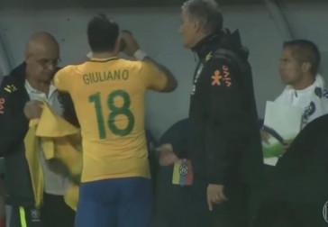 Giuliano é observado por Tite e toma água antes de ser orientado por Sylvinho, à direita da imagem