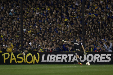 Cssio cobra tiro de meta no primeiro jogo da final da Libertadores, na Bombonera. Ao fundo, o mar de torcedores argentinos