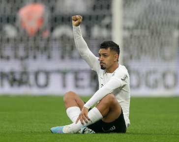 Matheus Bidu faz o sinal do punho serrado sentado na Neo Qu�mica Arena