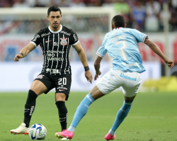 Giuliano prestes a realizar um passe enquanto � pressionado por jogador do Bahia