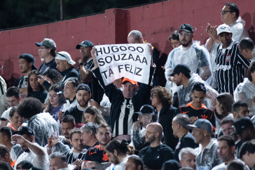 Torcedor do Corinthians estende faixa sobre Hugo Souza na arquibancada do Canind�