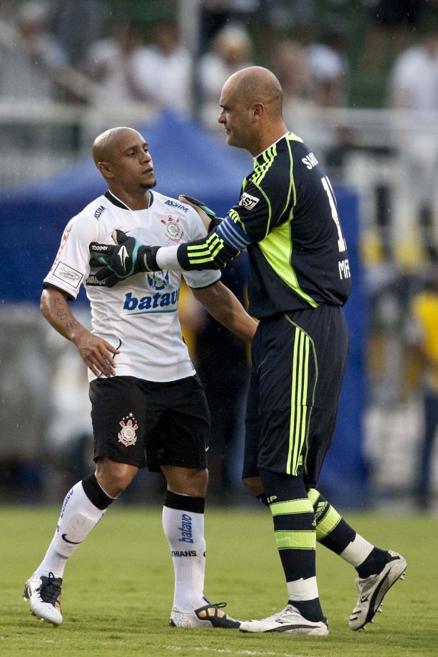 CORINTHIANS X PALMEIRAS - Roberto Carlos e seguro por Marcos após a sua explusao em um lance da partida realizada esta tarde no estádio do Pacaembu, zona oeste de São Paulo, válida pela 5ª rodada do Campeonato Paulista 2010