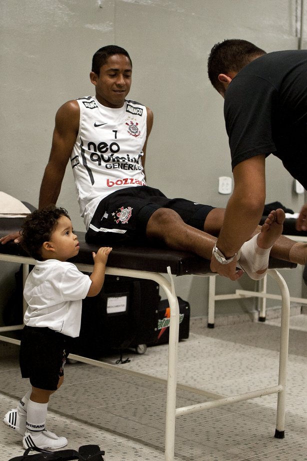 Jorge Henrique coloca protecao nos tornozelos com o enfermeiro Cleber Costa, ao lado do filho Thiago nos vestiários antes da partida entre Corinthians x Oeste/Itápolis, realizada esta noite no estádio do Pacaembu, quartas de final do Campeonato Paulista 2011