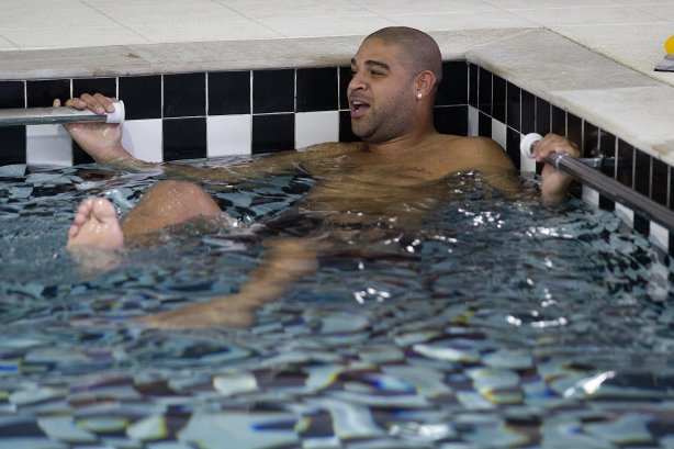 O atacante Adriano faz exercicios de fisioterapia na piscina ao lado do fisioterapeuta Caio Mello, esta tarde no CT Joaquim Grava, no Parque Ecológico do Tiete. O time se prepara para o jogo contra o Grêmio, domingo a tarde, dia 22/05, no estádio Olímpico, em Porto Alegre, pela 1ª rodada do Brasileirão 2011