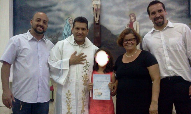 André, à esquerda, durante batizado da filha