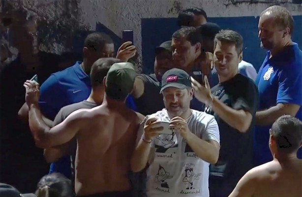 Assistindo o jogo nas arquibancadas, técnico Fábio Carille atende torcedores