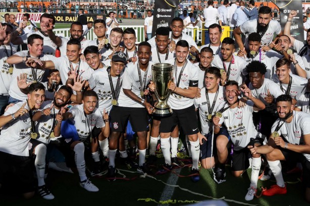 Jovens jogadores posam ao lado da taça