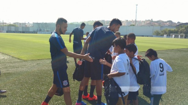 Jogadores presentearem crianas com kits de material escolar