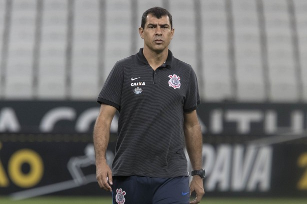 Fábio Carille caminha no gramado durante treino aberto à torcida