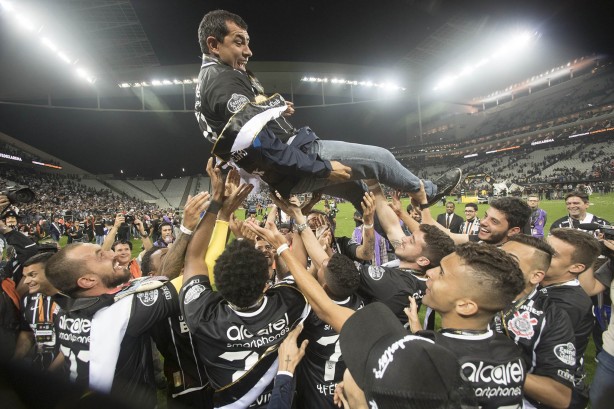 Jogadores erguem o técnico Fábio Carille em comemoração à conquista do Paulistão
