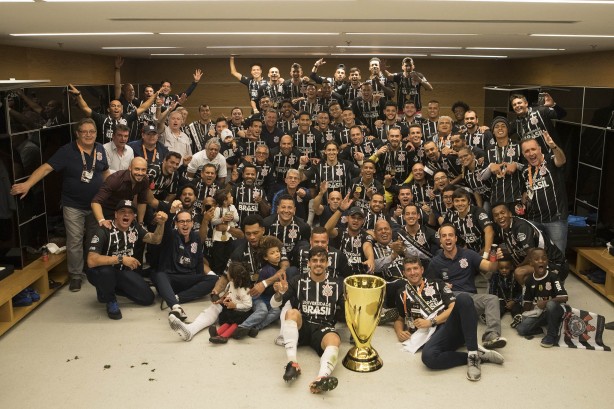 No vestiário, todo elenco corinthiano posa ao lado da taça do Paulistão