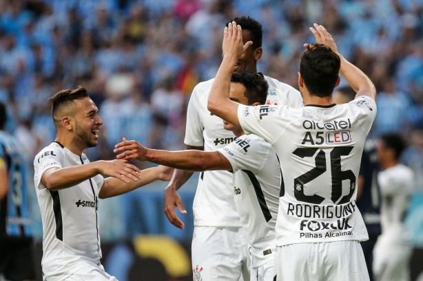 Outros jogadores chegam para comemorar o gol na Arena do Grêmio