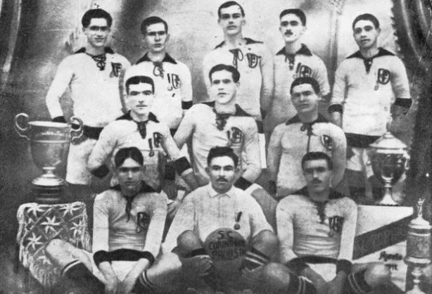 Elenco campeão paulista em 1914 ao lado da taça do primeiro título do Corinthians