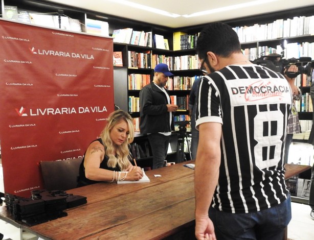 Katia autografa livro a torcedor vestido com a camisa da Democracia Corinthiana, liderada por Sócrates