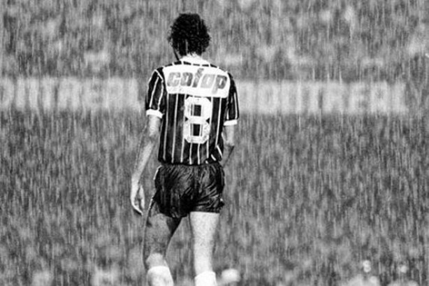 Sócrates vestindo a camisa preta com listras brancas do Corinthians