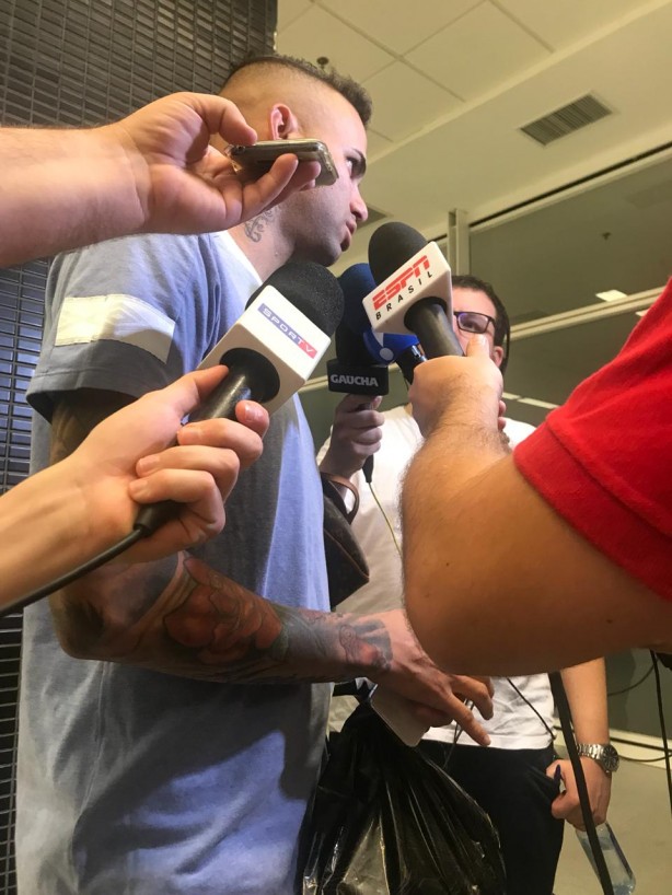 Sacola na mão de Luan, com diversas camisas do Corinthians