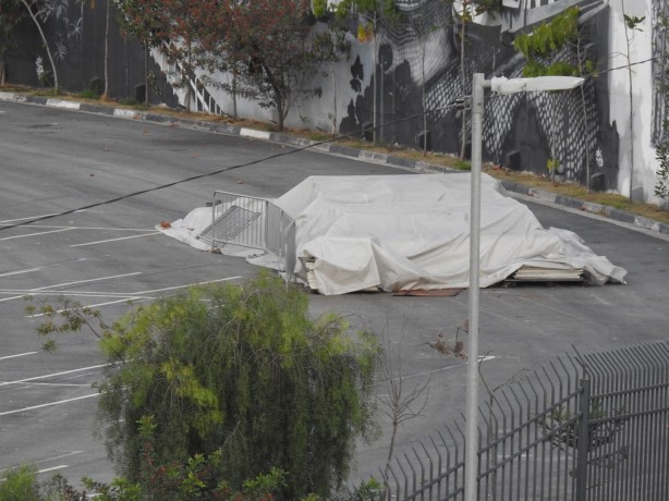 Entulho no estacionamento segue no local, coberto por um pano