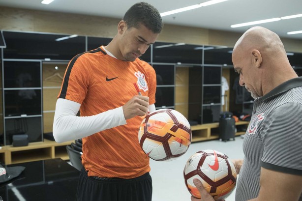 Léo Santos assina uma bola antes da partida contra o Colo-Colo