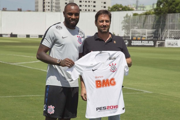 Manoel e Duílio segurando o manto do Corinthians durante apresentação do zagueiro