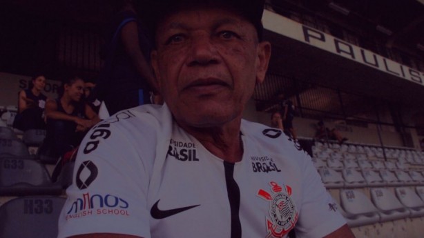 Olhar concentrado de Pedrão, pai do Pedrinho, ao assistir a partida