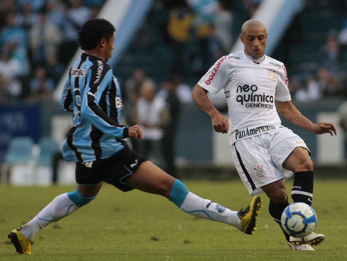 Roberto Carlos, do Corinthians,disputa a bola com o jogador Bergson do Grmio,em Partida vlida pelo campeonato brasileiro, no estdio Olmpico SP