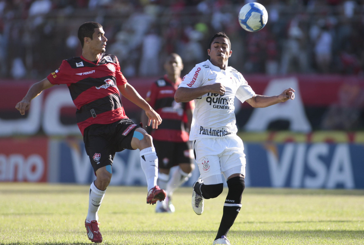 Jorge Henrique do Corinthians disputa a bola com o jogador Egdio do Vitoria durante partida vlida pelo Campeonato Brasileiro realizado no estdio do Barrado