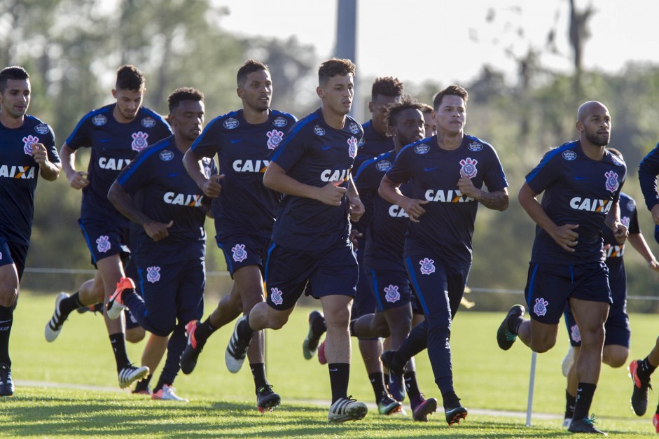 Elenco aquece no campo antes de treino técnico