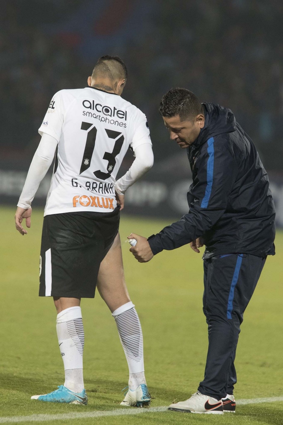 Guilherme Arana recebe atendimento na beira do campo durante duelo contra La U, no Chile