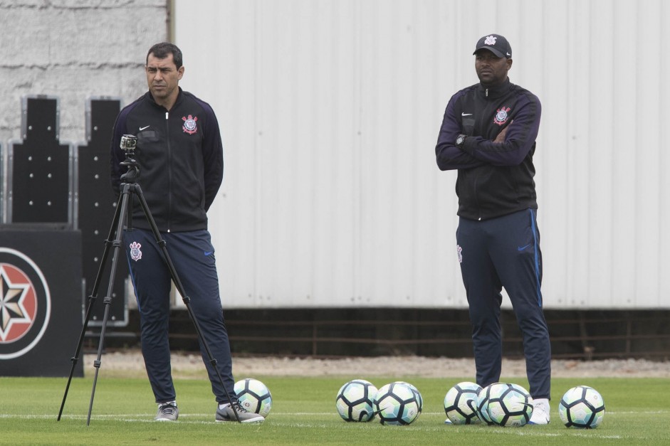 Carille e Fabinho observam o treino da manhã deste sábado, no CT