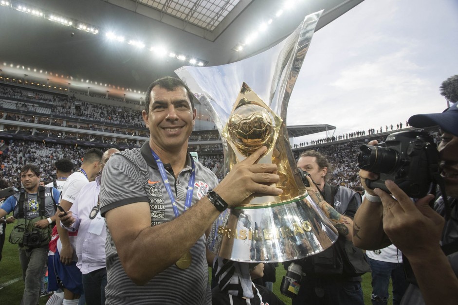 Carille posa com taa de campeo brasileiro na Arena Corinthians; treinador est de volta