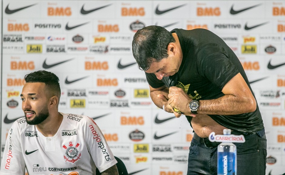 Carille encharcado com a brincadeira dos jogadores durante coletiva