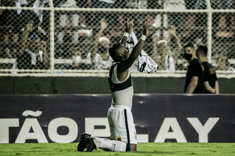 Paulinho ajoelhado comemorando o seu gol do Corinthians