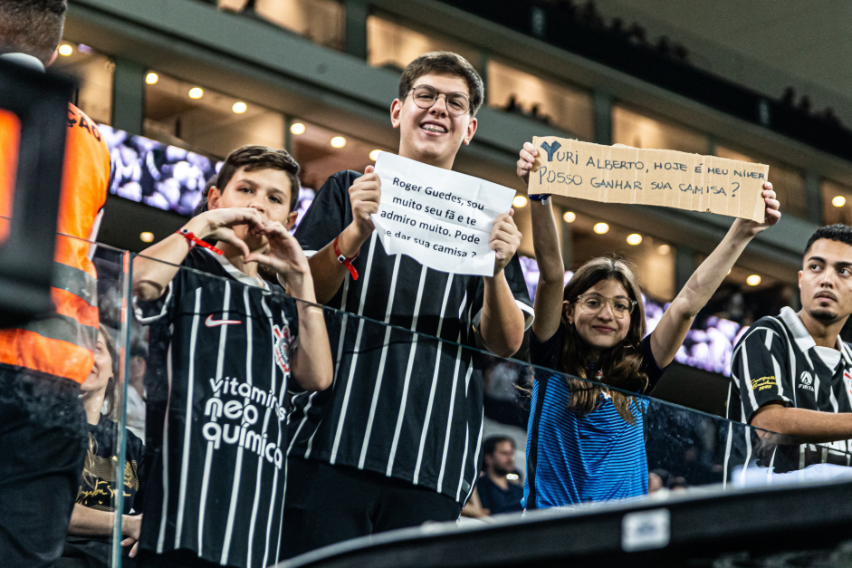 Jovens torcedores do Corinthians com cartazes pedindo as camisas de Rger Guedes e Yuri Alberto