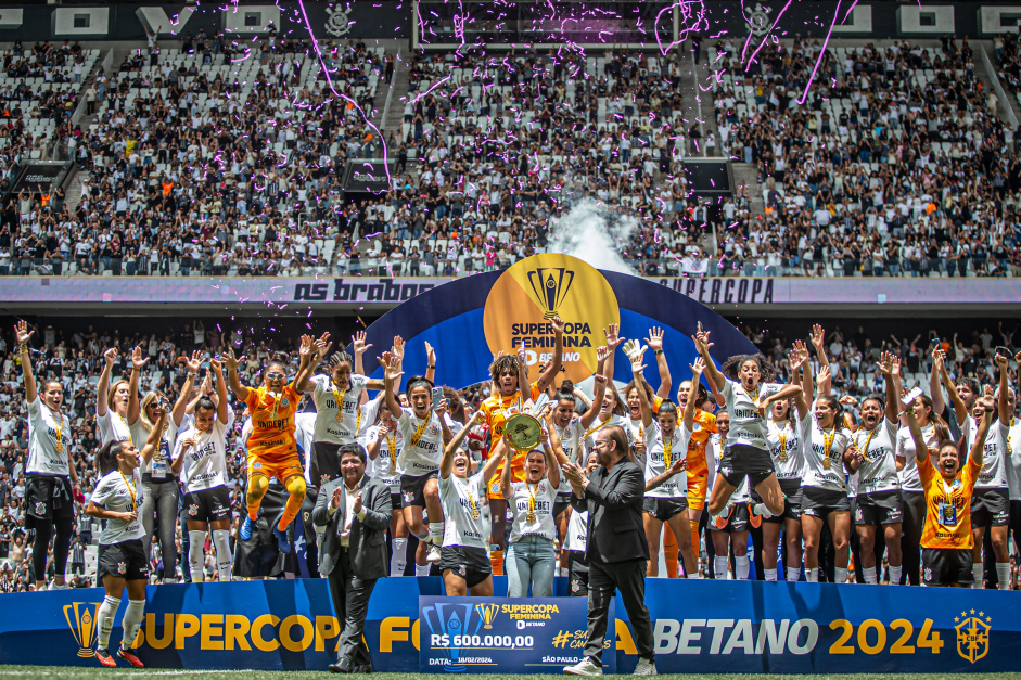Jogadoras celebrando com o trofu da Supercopa; atrs aparece a torcida